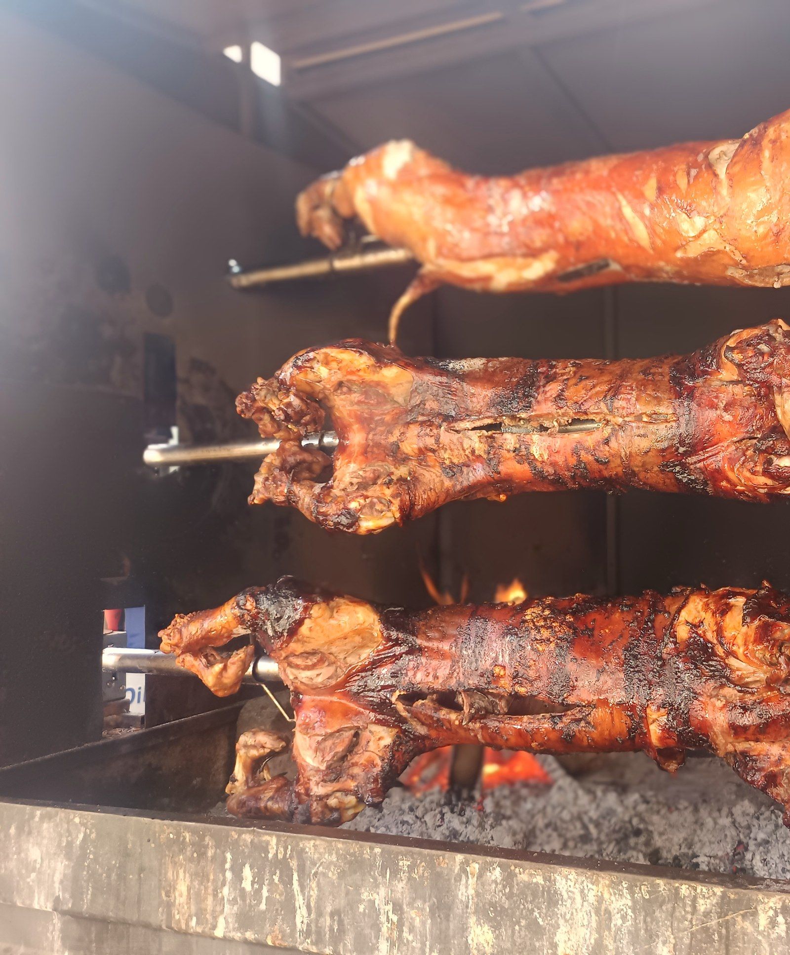 Spanferkel am Spieß über der Glut