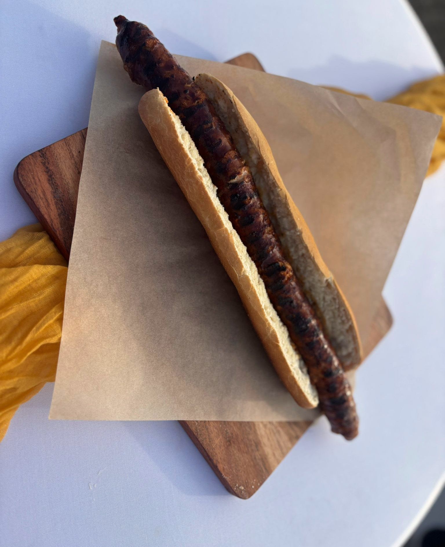 Kroatische Wurst im Baguette auf einem Holzbrett